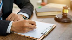 Lawyer Signing A Legal Document At His Desk