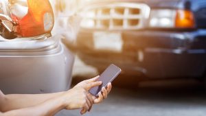 Man Using Smartphone To Report Car Accident